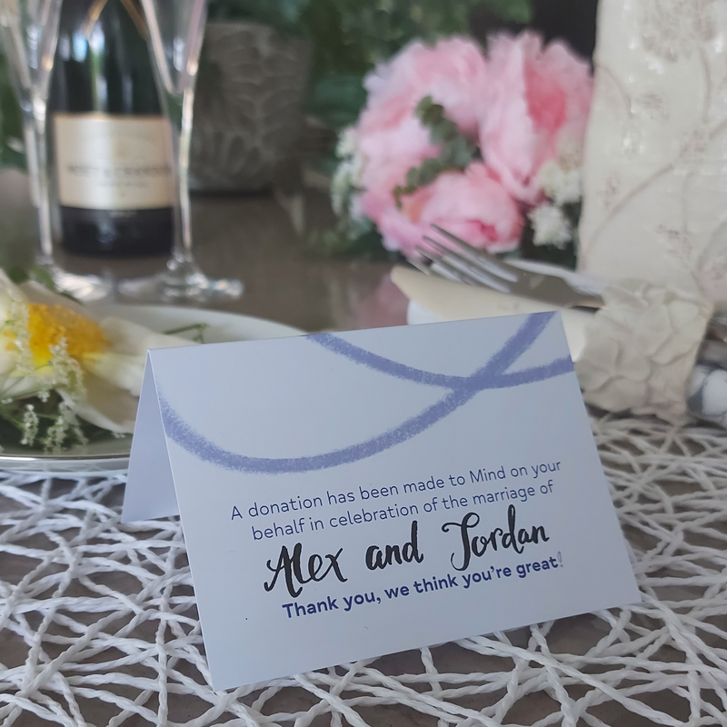 Mind's wedding tent cards says "a donation has been made to Mind on your behalf in celebration of the marriage of Alex and Jordan. Thank you, we think you're great!"