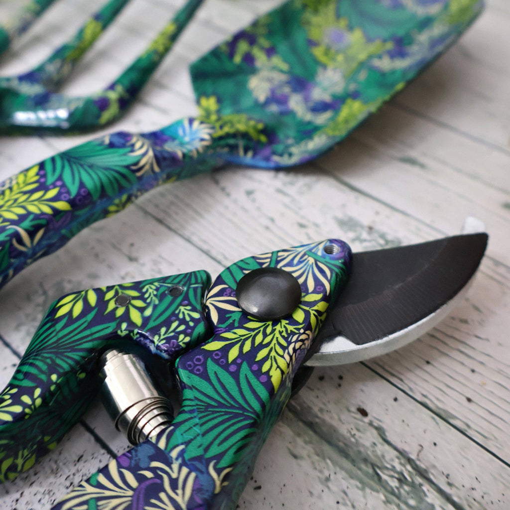 A pair of gardening tools featuring a vibrant green and blue floral pattern on their handles.