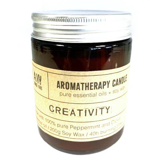 Aromatherapy candle in amber glass jar, infused with Peppermint and Clove essential oils, promoting creativity and relaxation.