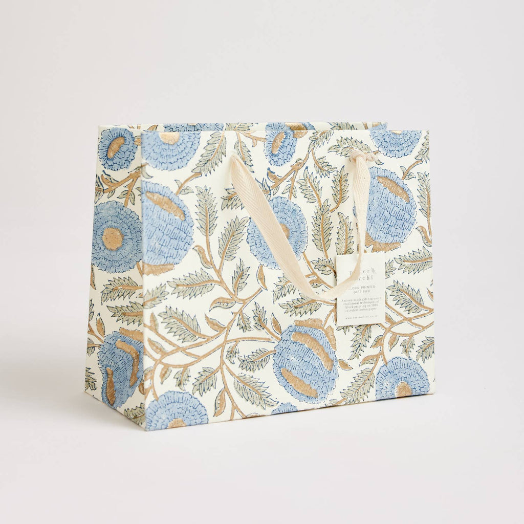 A medium blue and white floral print shopping bag made from recycled cotton card paper with artisanal rope handles.