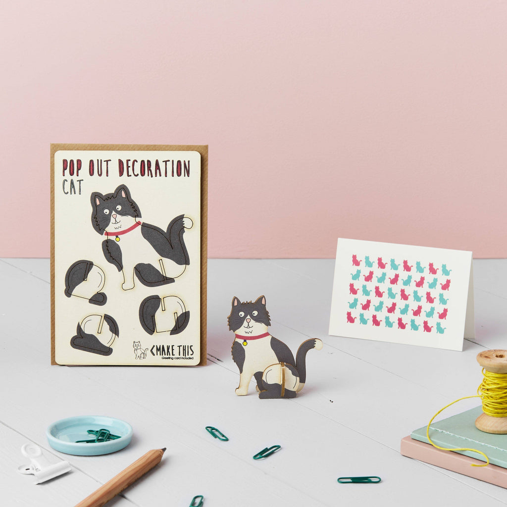 Black and white cat wooden pop out card on a school desk background with a pencil, paperclips and reel of yellow string
