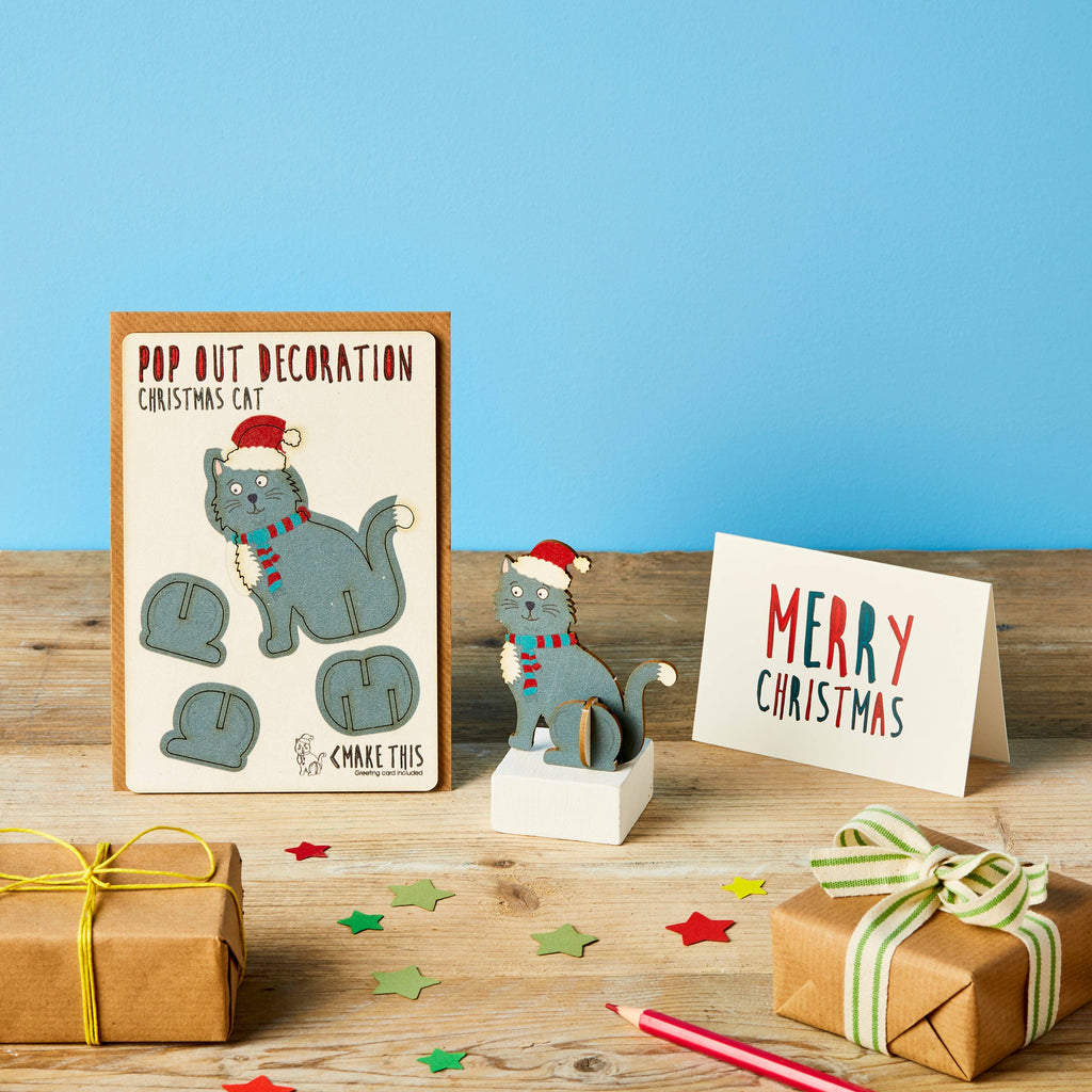 Christmas Cat Pop Out Card with grey body santa hat and red stripe scarf on a wooden table and blue background