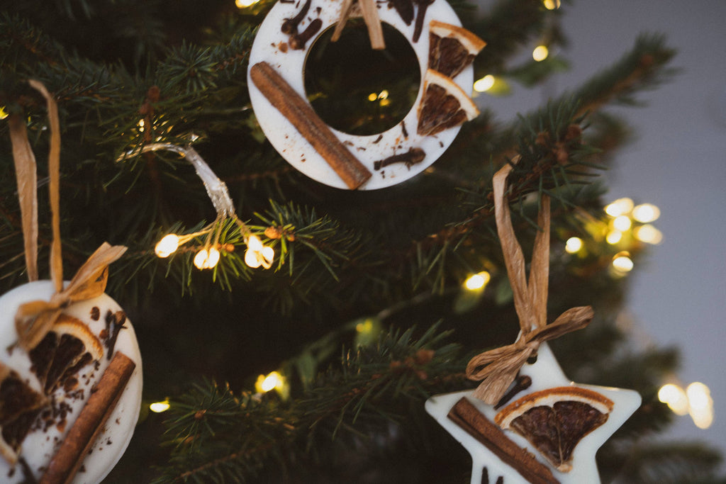 Christmas tree scented star, circle and wreath decorations hanging on Christmas tree with Christmas lights