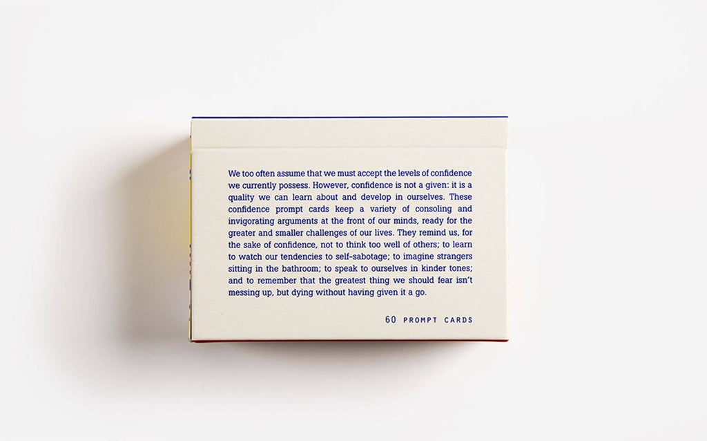 The back of the Confidence Cards box displaying a quote rests on a clean white surface, highlighting its text against the bright background.