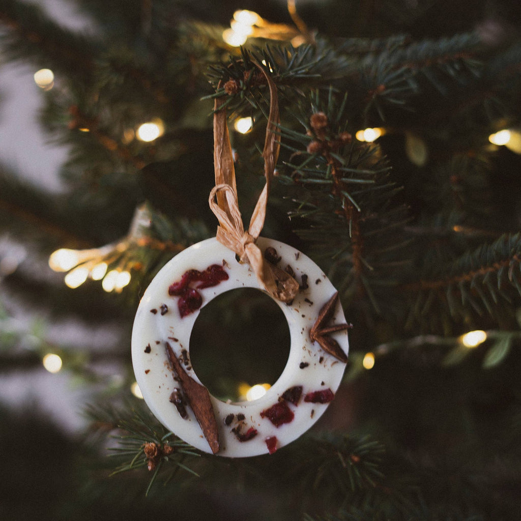 Cranberry orange and cinnamon Christmas scented decoration hanging on Christmas tree with Christmas lighting