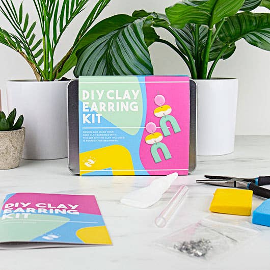 An assortment of supplies from a DIY clay earring kit arranged on a table, ready for crafting custom earrings.