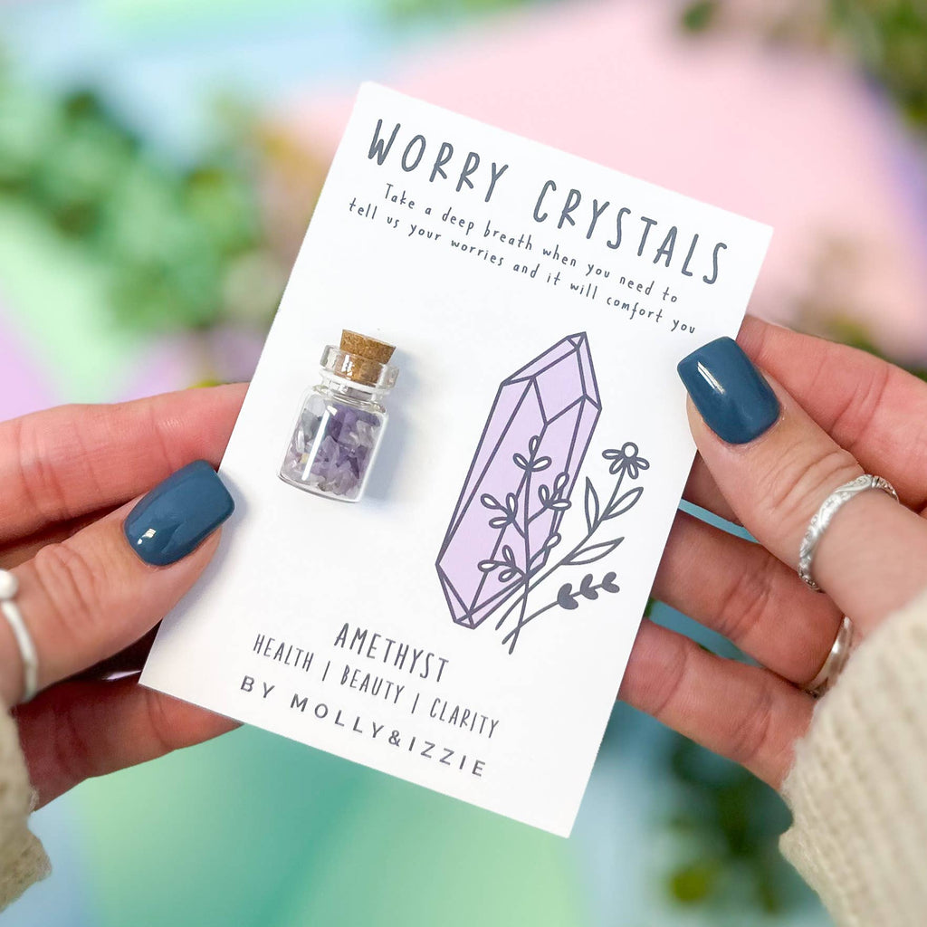 A woman presents a card that contains a beautiful crystal, emphasizing its clarity and captivating design.