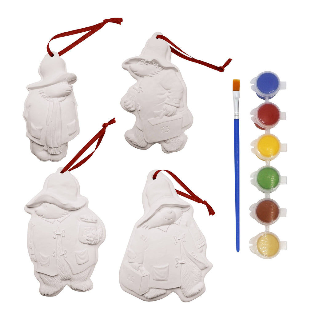 Adorable Paddington Bear ornaments for Christmas, adding a playful touch to your festive decorations. Undecorated next to brush and paint pots. 