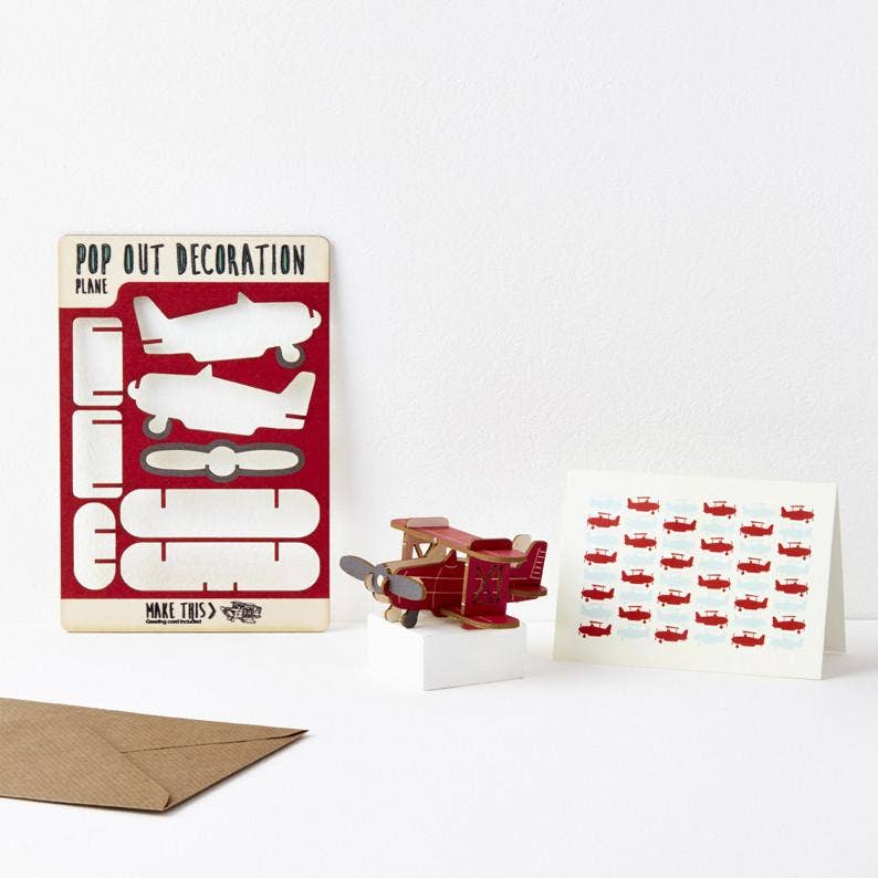 Red propeller plane pop out wooden card on a white little podium 