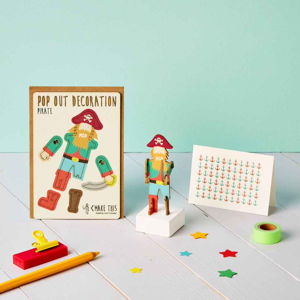 A crafted pirate made of paper, accompanied by a note and a pencil, illustrating a playful and imaginative scene.