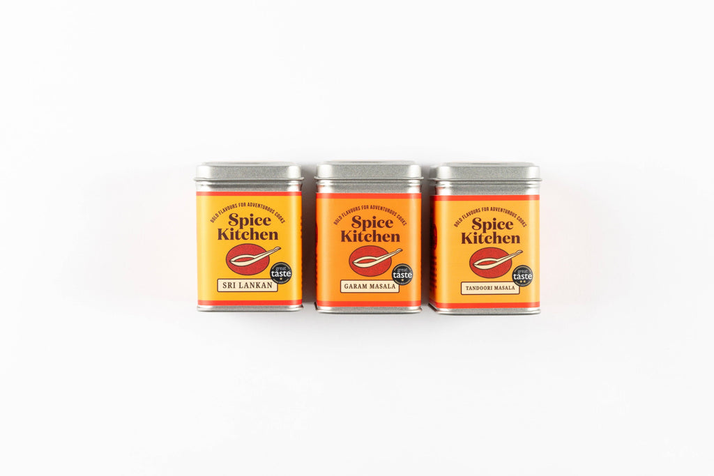 A trio of spice tins on a white background, each featuring unique colours and names of the spices inside.