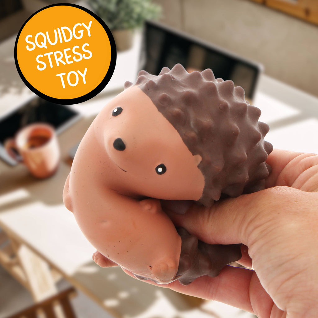 A hand holds a hedgehog stress toy labelled "Soundly Stress Toy," showcasing its soft texture and playful design.