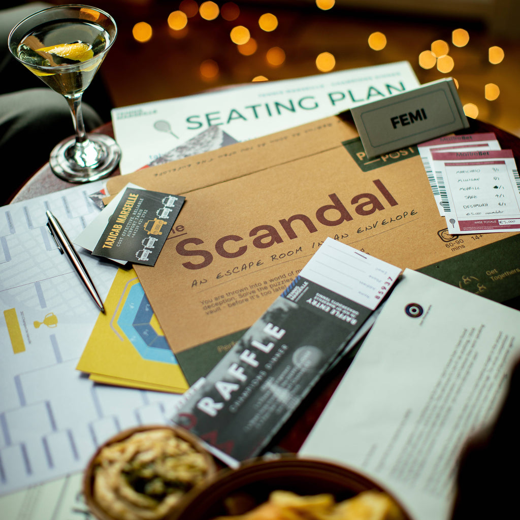 A table arranged with a drink and The Scandal Puzzle, ideal for enjoying a cosy afternoon.