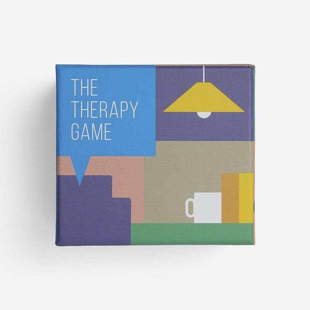 A therapy game box sits next to a coffee cup and an open book on a cozy table illustration.