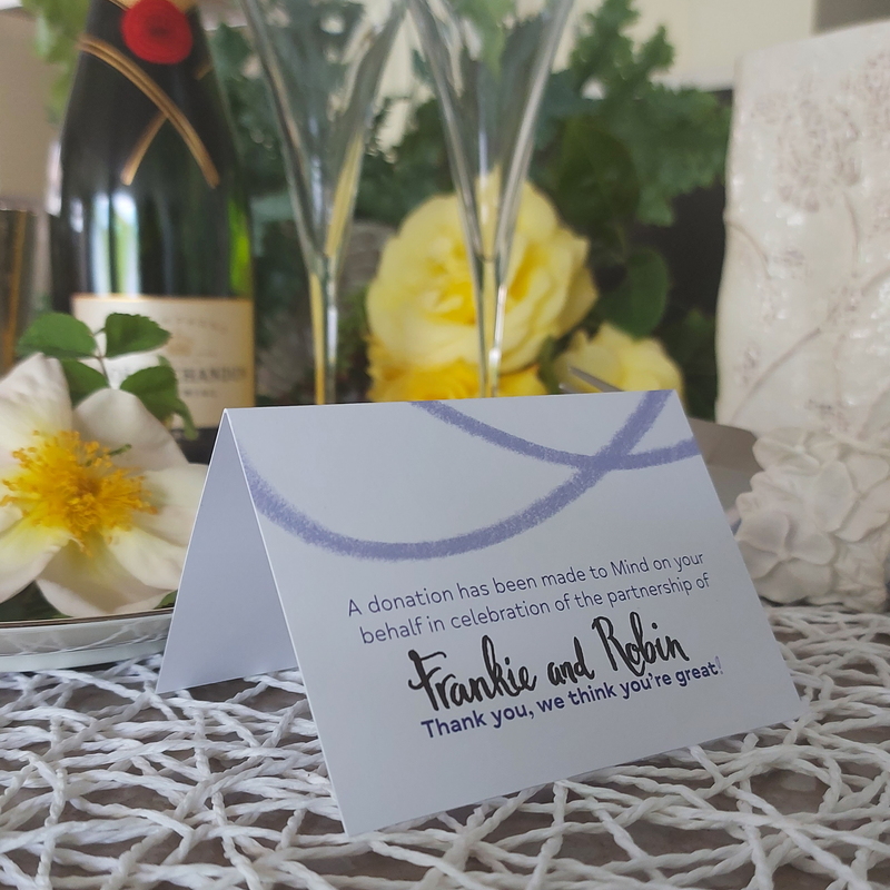Image of our wedding tent cards for partnership celebrations. Card reads "a donation has been made to Mind on your behalf in celebration of the partnership of Frankie and Robin. Thank you, we think you're great!"